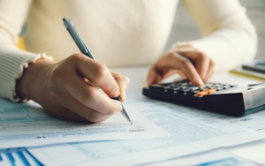 Photo of person writing and using a calculator