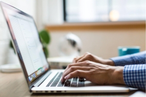 Photo of person's hands using laptop